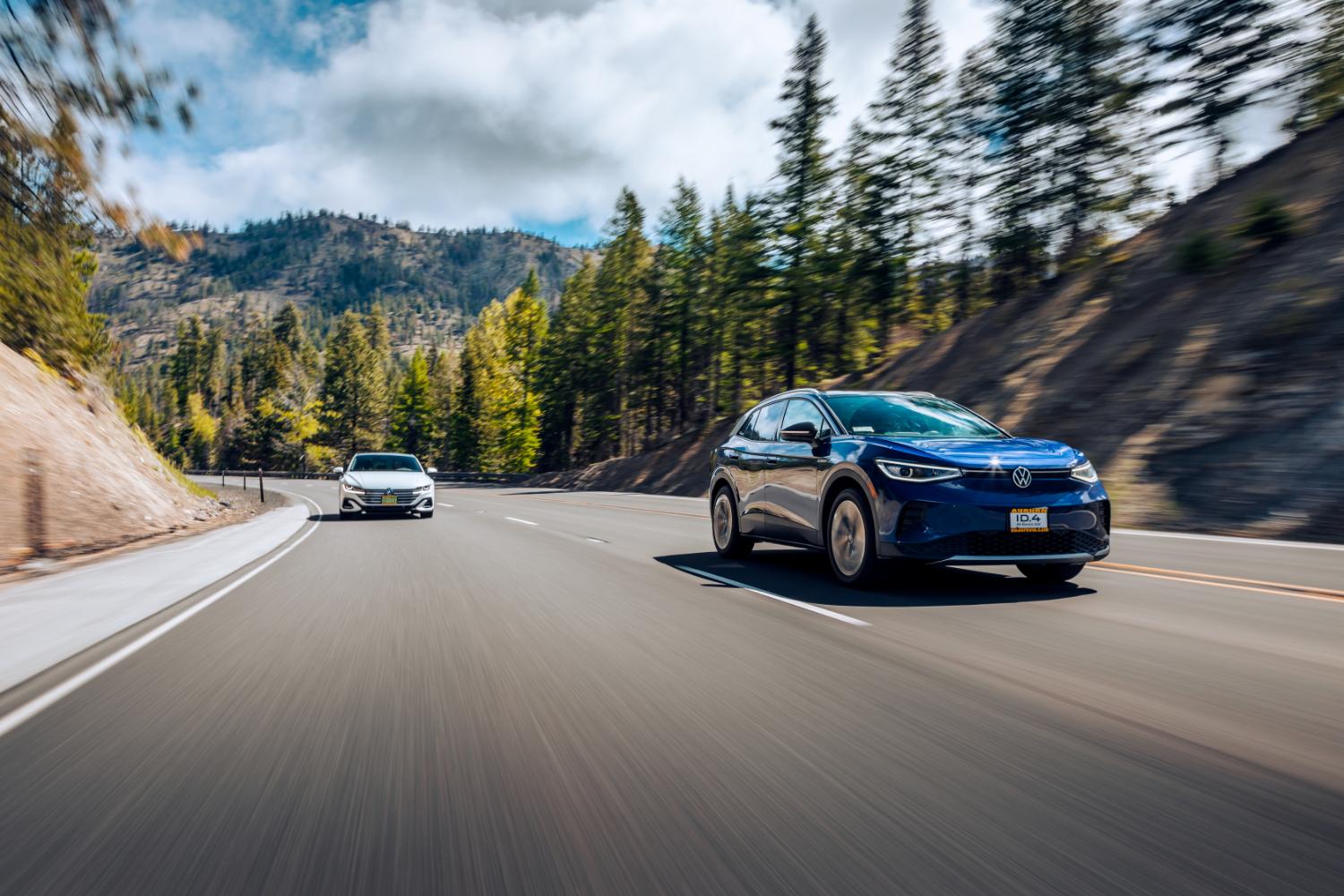 A blue Volkswagen ID.4 electric SUV driving on a mountain highway.
